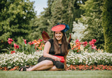 Small red saucer with navy edge and feather detail